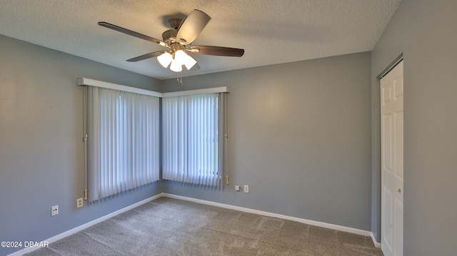 unfurnished room featuring a textured ceiling, ceiling fan, and carpet floors