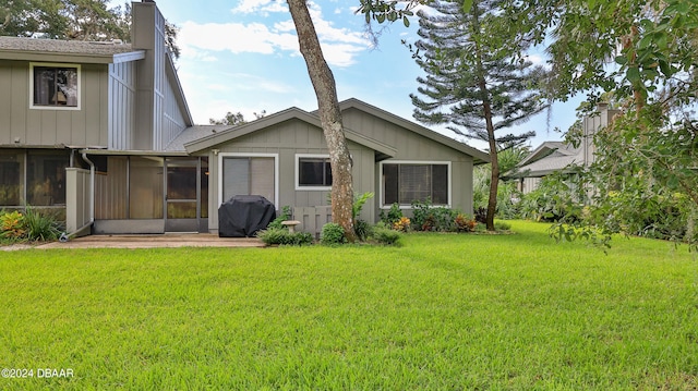 back of house with a sunroom and a yard