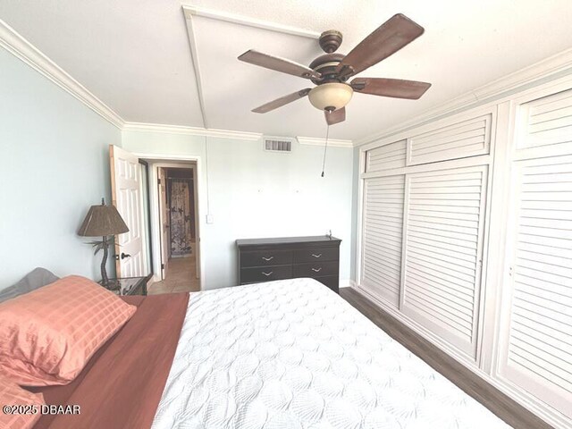2800 N Atlantic Ave Unit 1206, Daytona Beach, FL 32118 - bedroom with crown molding, a closet, ceiling fan, and dark wood-style flooring