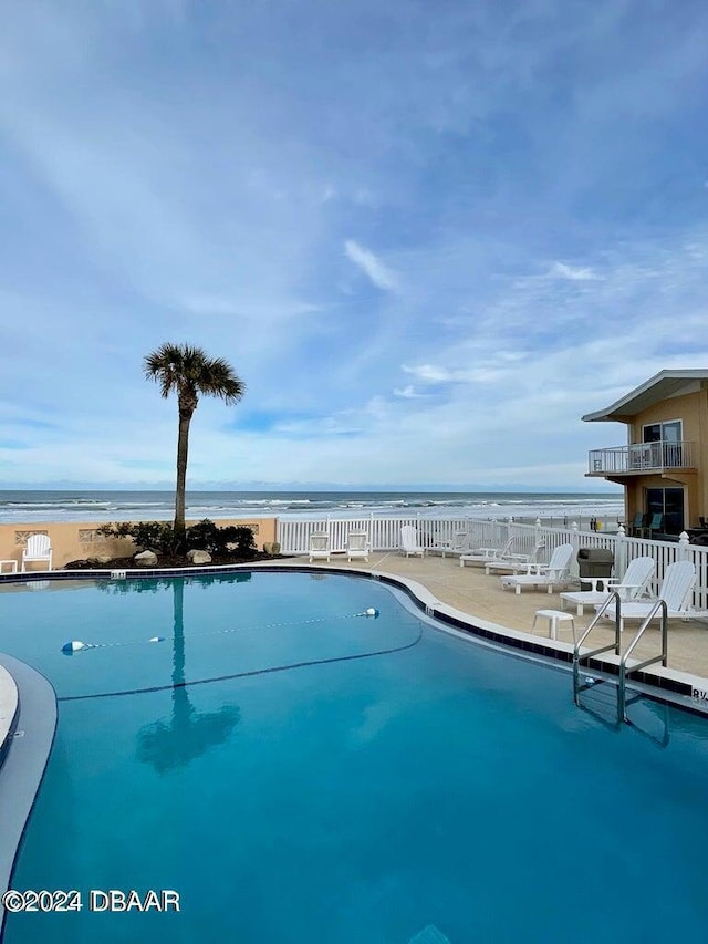 view of pool featuring a beach view and a water view