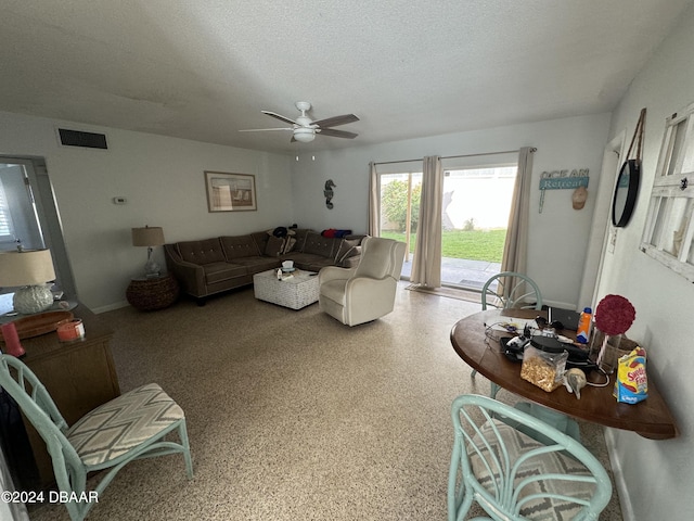 living room with a textured ceiling and ceiling fan