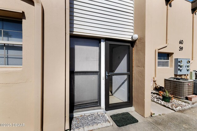 5500 Ocean Shore Blvd Unit 58, Ormond Beach, FL 32176 - view of exterior entry featuring central AC unit and stucco siding