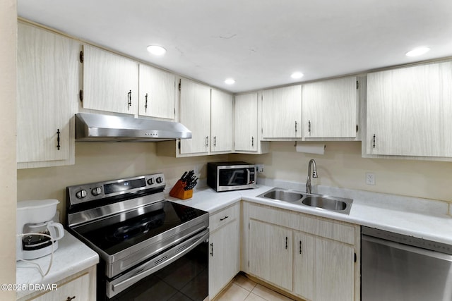 5500 Ocean Shore Blvd Unit 58, Ormond Beach, FL 32176 - kitchen with stainless steel appliances, under cabinet range hood, a sink, light countertops, and light tile patterned floors