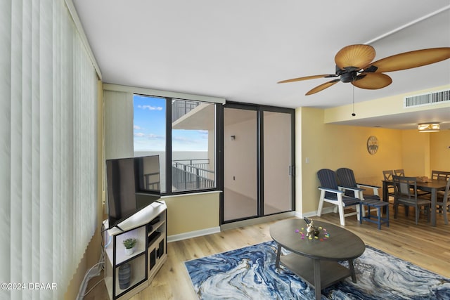 living room with light hardwood / wood-style flooring and ceiling fan