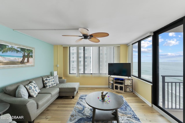 living room featuring ceiling fan, plenty of natural light, and light wood-type flooring