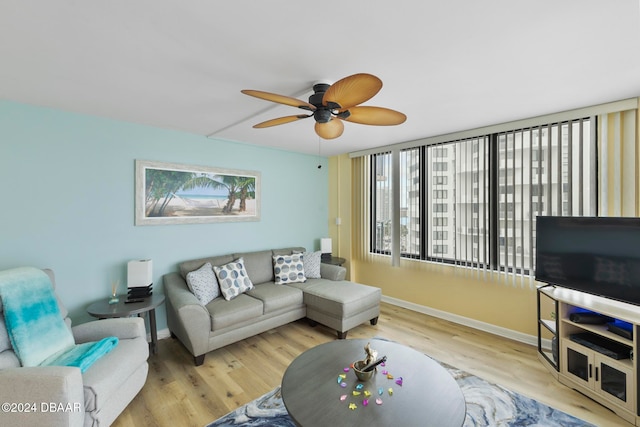 living room featuring ceiling fan, plenty of natural light, and light wood-type flooring