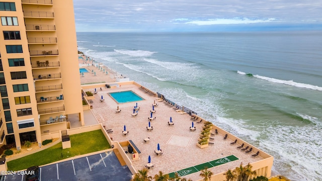 drone / aerial view featuring a water view and a view of the beach