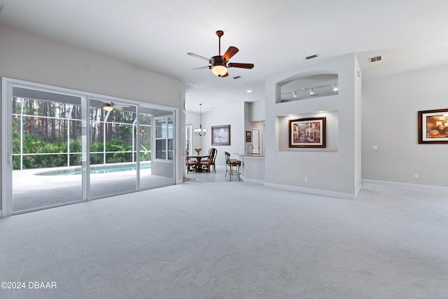 unfurnished living room with carpet flooring and ceiling fan with notable chandelier