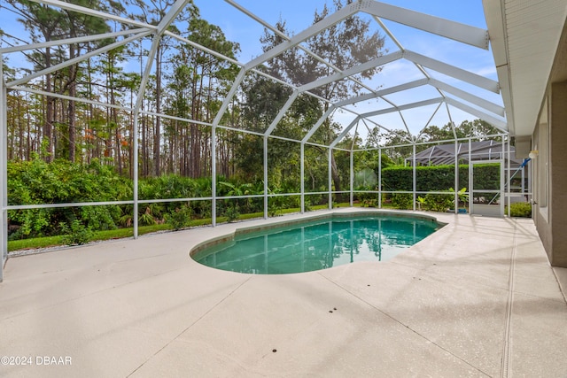 view of swimming pool with glass enclosure and a patio area