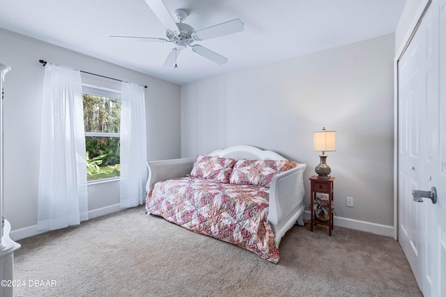 carpeted bedroom with ceiling fan and a closet