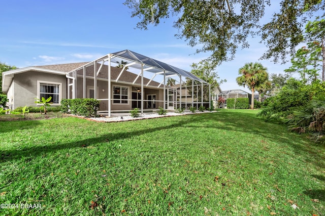 1317 Harwick Ln, Ormond Beach, FL 32174 - back of property with a lawn, glass enclosure, and stucco siding