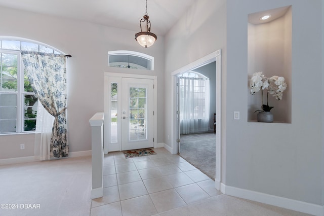 foyer featuring light carpet and a wealth of natural light