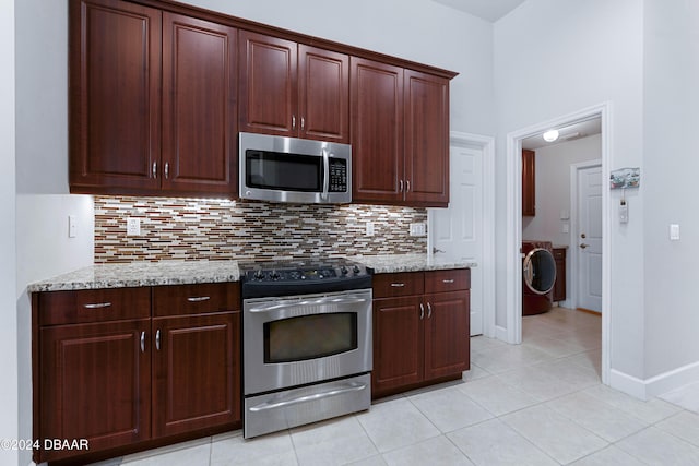 1317 Harwick Ln, Ormond Beach, FL 32174 - kitchen with stainless steel appliances, washer / dryer, decorative backsplash, light tile patterned floors, and light stone counters