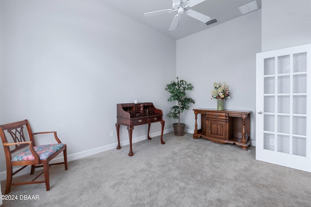 living area featuring light carpet and ceiling fan