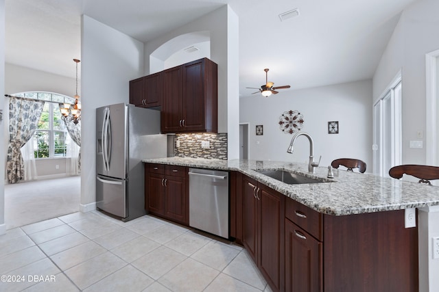 kitchen featuring kitchen peninsula, appliances with stainless steel finishes, ceiling fan with notable chandelier, sink, and light tile patterned floors