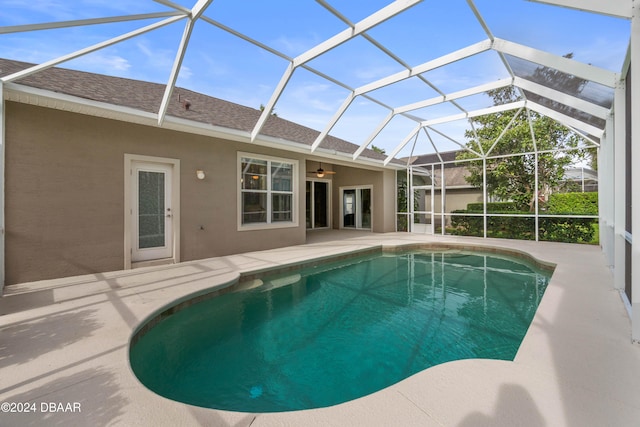 view of swimming pool with a patio area, ceiling fan, and a lanai