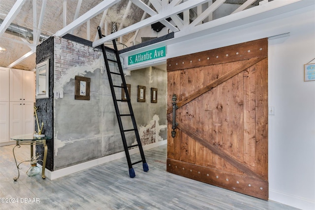 interior space with a barn door and hardwood / wood-style flooring