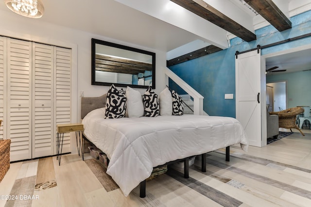 830 Maralyn Ave, New Smyrna Beach, FL 32169 - bedroom featuring a barn door, wood finished floors, and beamed ceiling