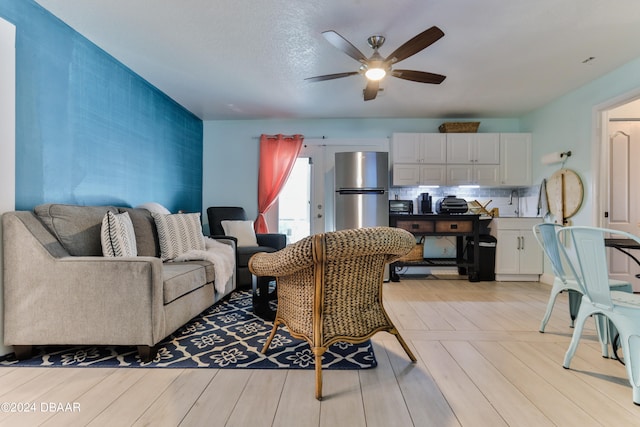 living room with light hardwood / wood-style floors and ceiling fan