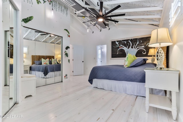 bedroom with hardwood / wood-style flooring, multiple windows, and vaulted ceiling with beams