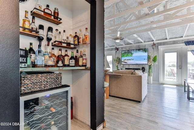 bar with light hardwood / wood-style floors, ceiling fan, and wine cooler