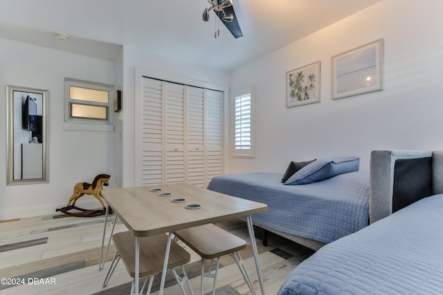 bedroom featuring light wood-type flooring, ceiling fan, and a closet