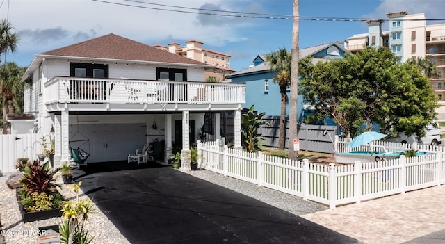 830 Maralyn Ave, New Smyrna Beach, FL 32169 - view of front of home featuring driveway, an attached garage, and a balcony