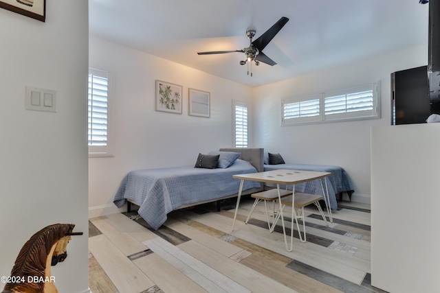 bedroom with light hardwood / wood-style flooring, multiple windows, and ceiling fan