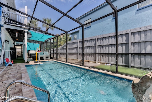 view of swimming pool featuring a lanai and a patio