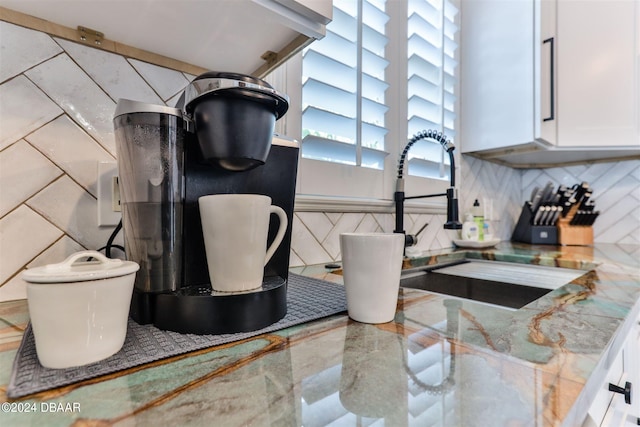 interior details with white cabinetry, sink, and tile counters