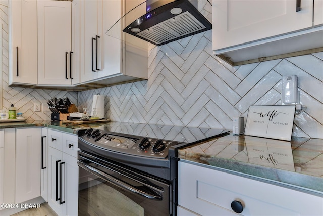 kitchen with white cabinetry, wall chimney range hood, tasteful backsplash, and electric range