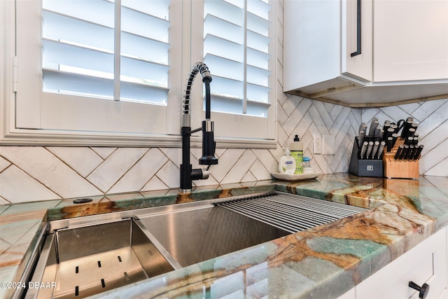 room details with backsplash, sink, and white cabinets