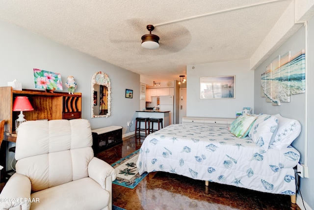 800 N Atlantic Ave Unit 516, Daytona Beach, FL 32118 - bedroom featuring freestanding refrigerator, baseboards, a ceiling fan, a textured ceiling, and tile patterned flooring