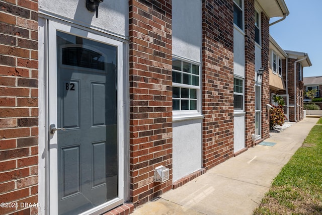 doorway to property with brick siding