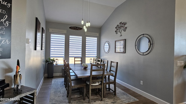 dining area featuring dark wood-type flooring and vaulted ceiling