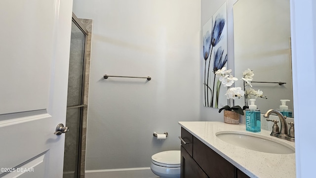 bathroom with vanity, toilet, and a shower with door