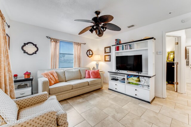 tiled living room with ceiling fan