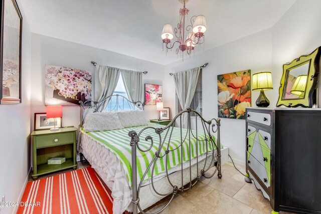 tiled bedroom with a notable chandelier