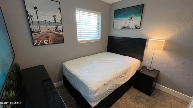 bedroom featuring carpet flooring, baseboards, and a textured wall