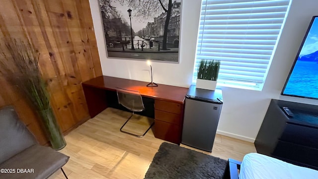 office with light wood-style flooring and built in desk