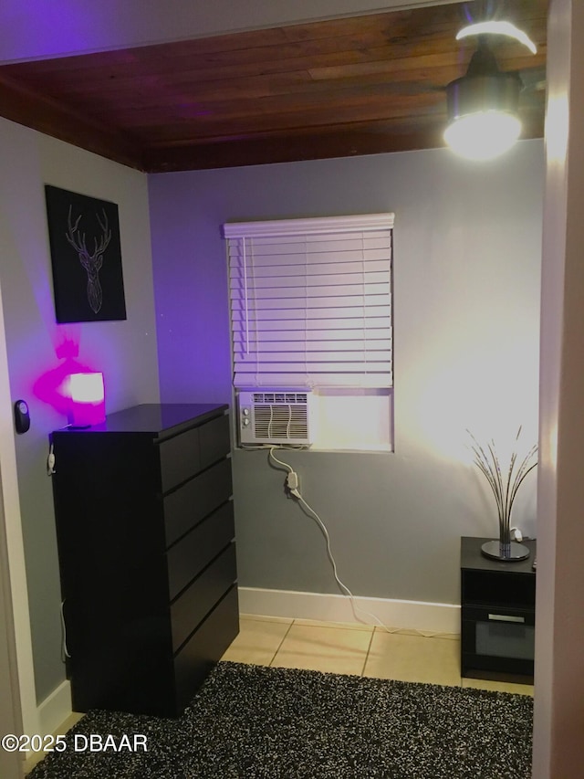 interior space featuring tile patterned floors, wooden ceiling, and baseboards