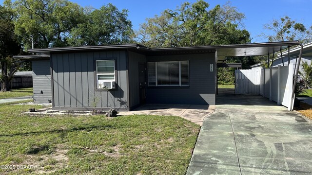 view of front of property featuring a carport, concrete driveway, a front yard, and fence