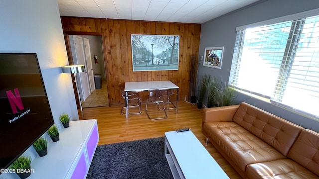 living area with wood finished floors and wood walls