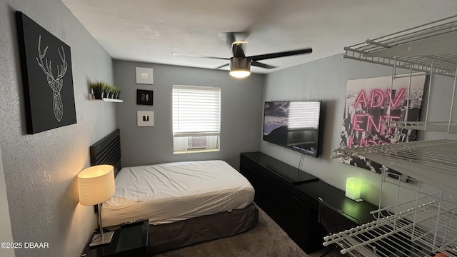 carpeted bedroom featuring cooling unit, a ceiling fan, and a textured wall