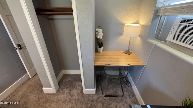 office area with carpet flooring, baseboards, and a textured wall