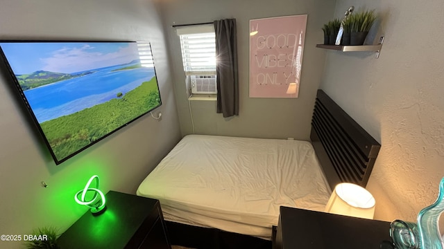 bedroom featuring cooling unit and a textured wall