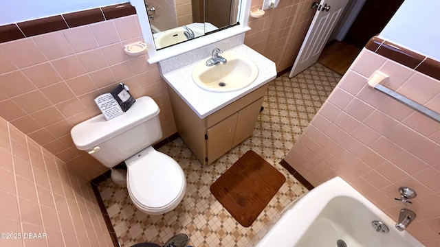 full bathroom featuring vanity, tile walls, and toilet