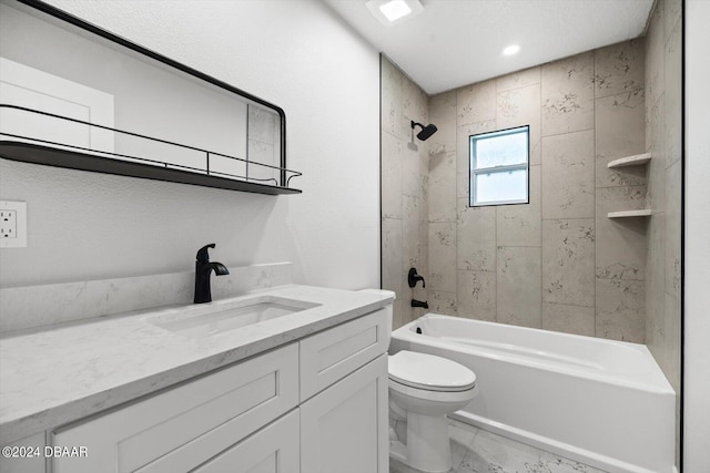 full bathroom featuring vanity, tiled shower / bath, and toilet