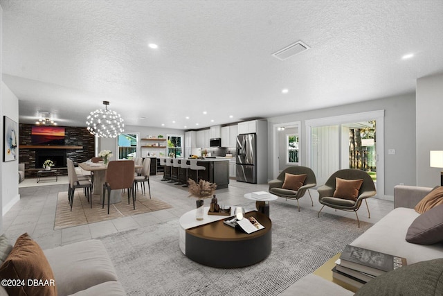 tiled living room featuring a notable chandelier and a textured ceiling