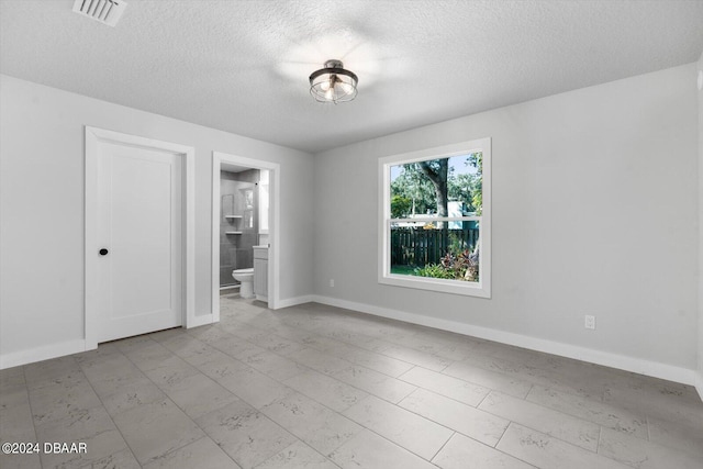 unfurnished room featuring a textured ceiling